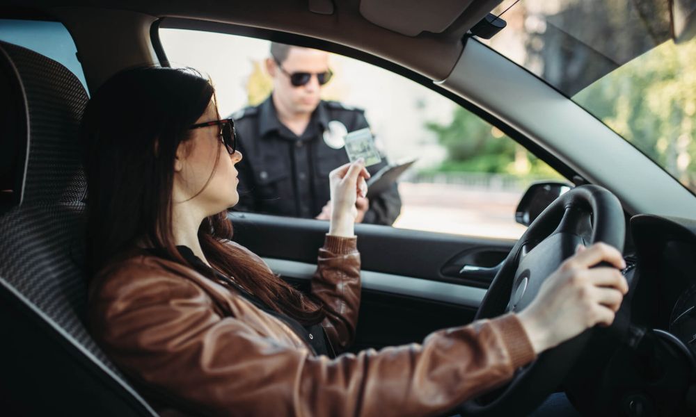 Male cop in uniform writes a fine to female driver